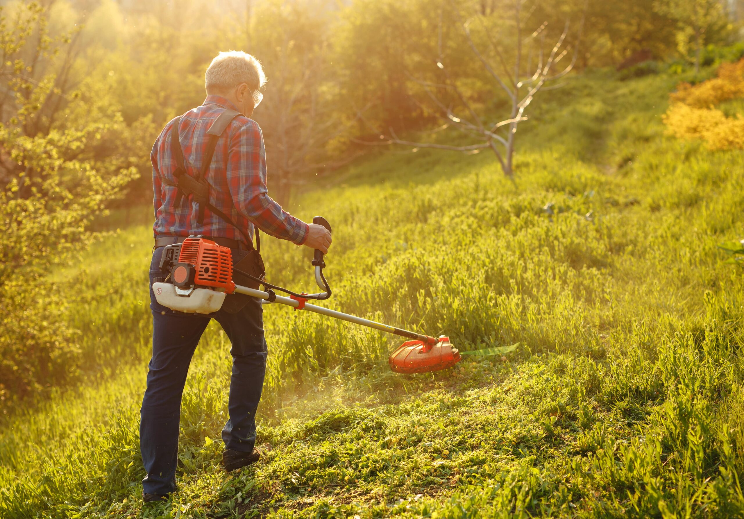 hombre desbrozando su terreno. Césped alto